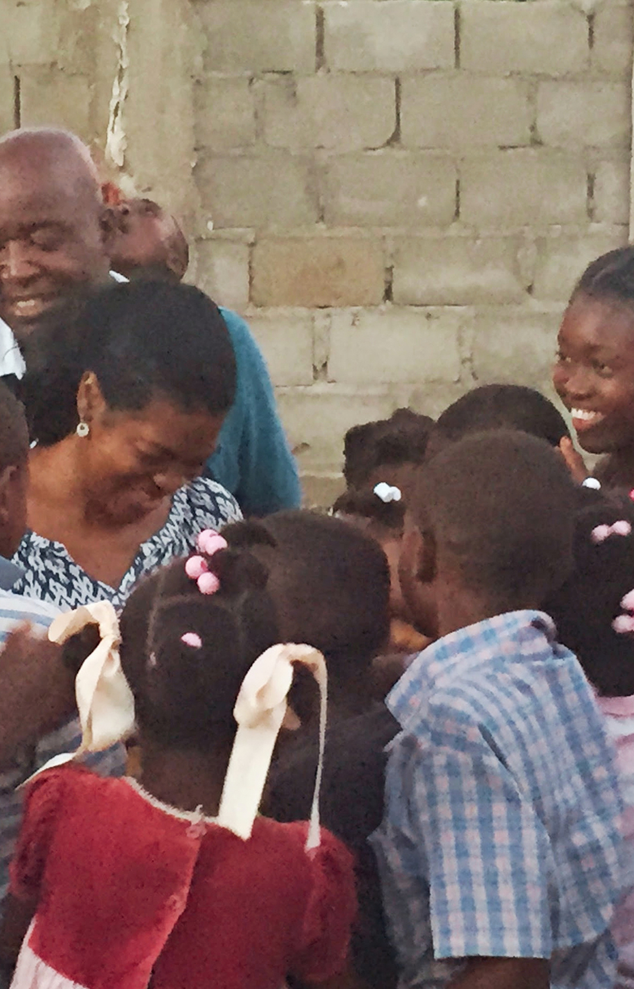 Dr. Blossom A. Burton surrounded by children and families during a community visit in Haiti